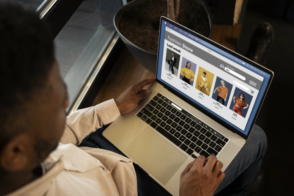 Homem com a tela do notebook aberta, mexendo em um site de e-commerce