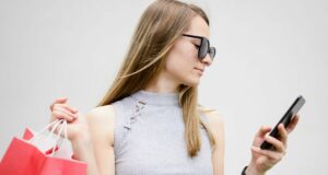 Cliente mexendo no celular com uma mão e segurando o celular na outra