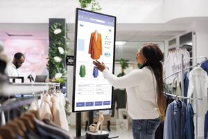 mulher comprando roupas no toten da loja automatizado